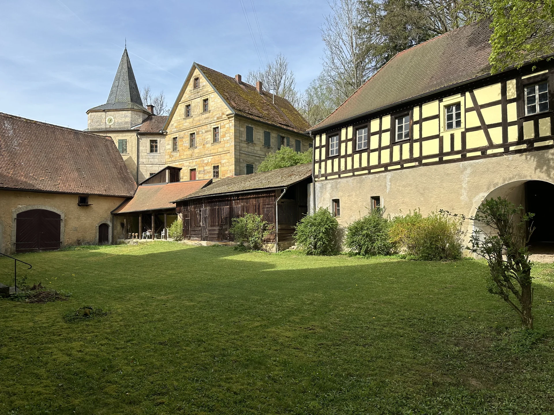 The green castle courtyard, with stone walls and a timber-framed gallery