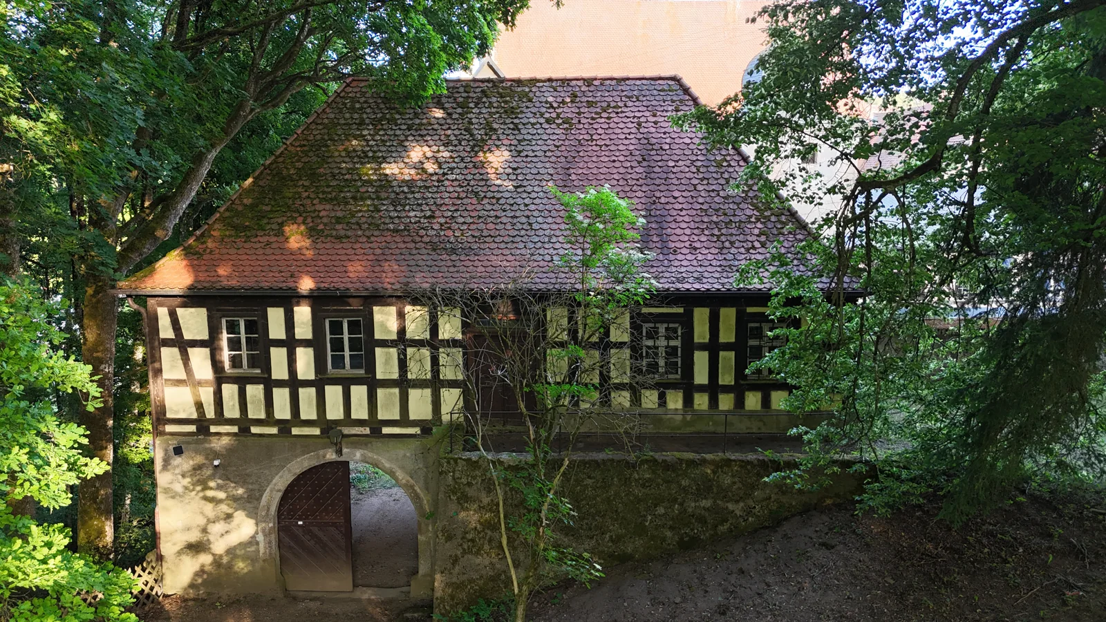 Das Torhaus mit Fachwerkfassade, Ziegeldach und rundbogiger Durchfahrt